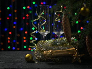 İki bardak ve şenlikli bir arka planda kapalı bir şişe şampanya..