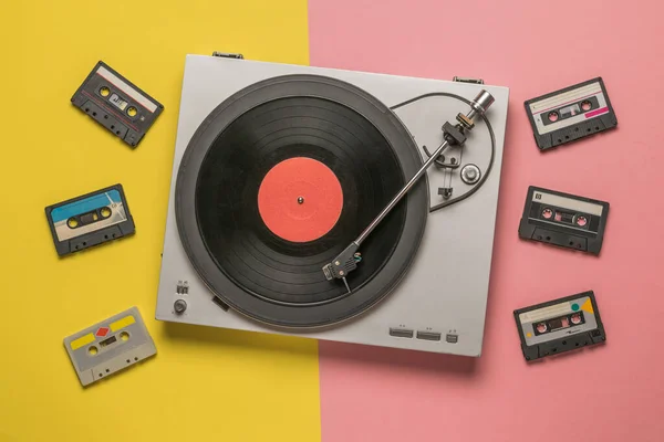 Vinyl record player and tape recorders on a yellow and pink background. — Stock Photo, Image