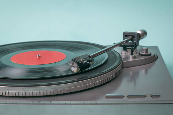 Vinyl record player on a light blue background.