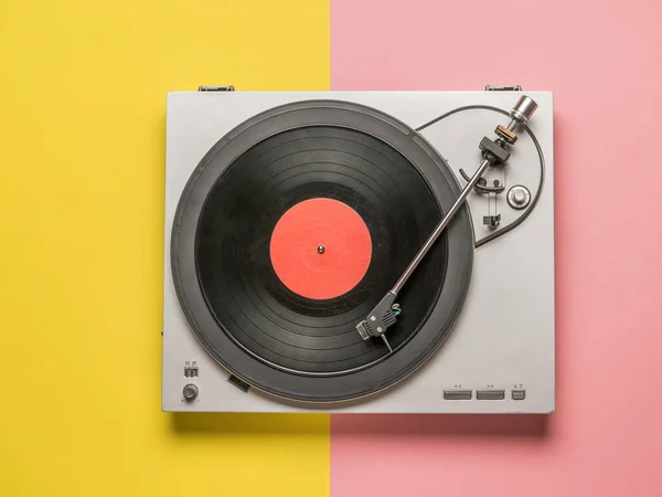 Top view of a vinyl record player on a red and yellow background. — Stock Photo, Image