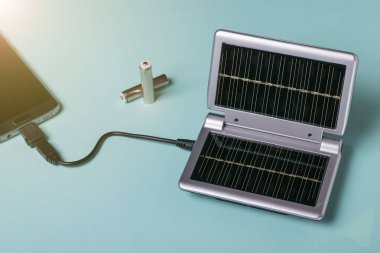 Modern bir cep telefonunun güneş enerjisinden şarj oluyor. Güneş enerjisi kullanımı. Gelecek teknolojisi.