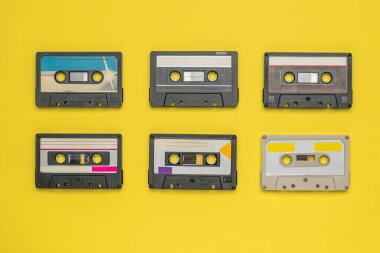 Sarı arka planda manyetik bantlı altı ses kaseti. Klasik ses kayıt depolama ve çalma araçları.