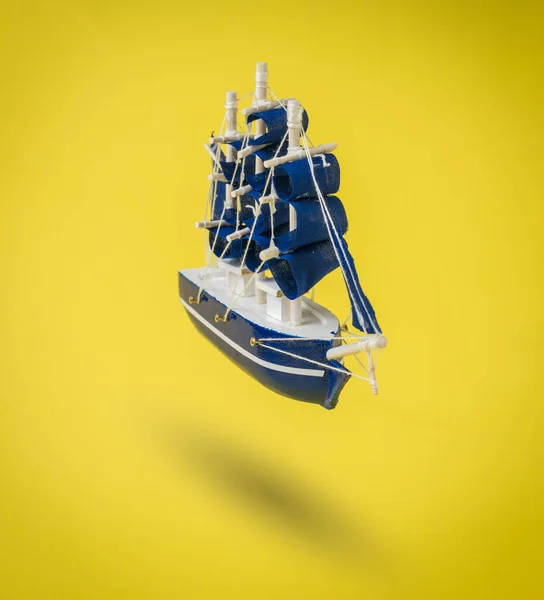 Ein Blaues Schiff Mit Segeln Auf Leuchtend Gelbem Hintergrund Ein — Stockfoto