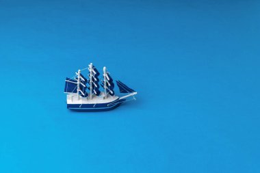 Denizde yüzen mavi yelkenli bir yelkenli. Seyahat ve macera kavramı.