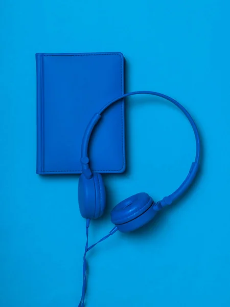 Сині Навушники Блакитним Шкіряним Блокнотом Синьому Фоні Монохромне Зображення Офісних — стокове фото