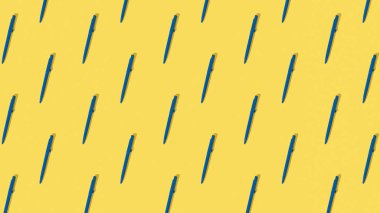 Sarı arka planda mavi tükenmez kalem deseni. Ofis malzemeleri.