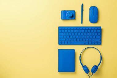 Açık sarı arka planda mavi ofis aksesuarları. Ticari ve serbest aksesuarlar için şık aksesuarlar. Düz yatıyordu.