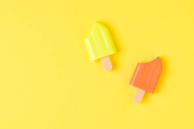 Sarı arka planda turuncu ve sarı buzlu şeker. Popüler bir yaz atıştırması.