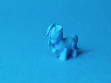 Mavi arka planda mavi bir oyuncak. Modaya uygun bir oyuncağın tek renkli görüntüsü.