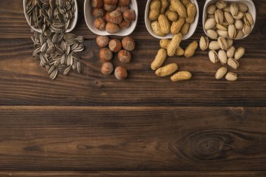 White ceramic cups with spilled nuts and seeds. A mixture of nuts and seeds.
