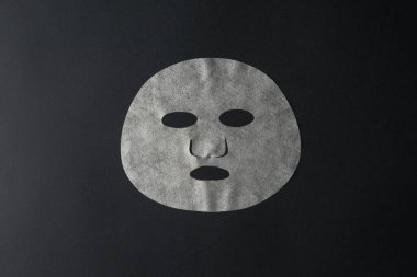 Siyah arka planda beyaz yüz maskesi. Yüz bakımı ve görünüm değişiklikleri maskesi.