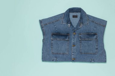 Açık mavi arka planda sofistike bir kot ceket. Popüler günlük kıyafetler..