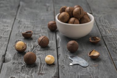 Tahta bir masada metal anahtarı olan Macadamia fındıkları. Süper yemek..