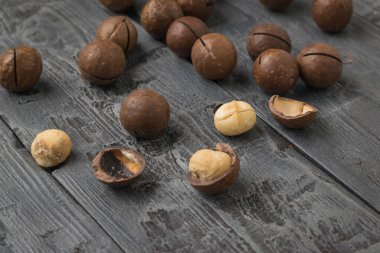 Ahşap bir masaya saçılmış, soyulmuş macadamia fındıkları. Süper yemek..