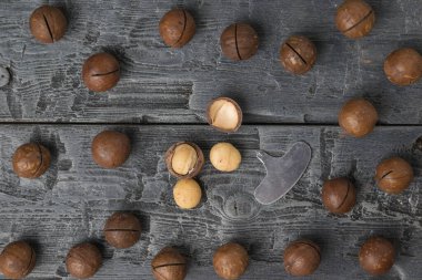 Dağınık Macadamia fındıkları olan siyah ahşap bir masanın üst görüntüsü. Süper yemek..