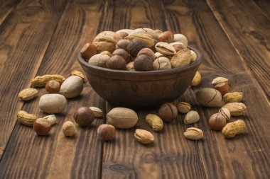 Ceviz karışımı, toprak kabından koyu ahşap bir masanın üzerine dökülüyor. Vejetaryen yemeği..