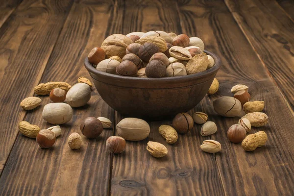 Ceviz karışımı, toprak kabından koyu ahşap bir masanın üzerine dökülüyor. Vejetaryen yemeği..