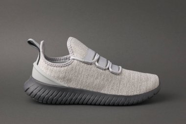 Koyu gri arka planda gri renkli koşu ayakkabısı. Spor yaşam tarzı..