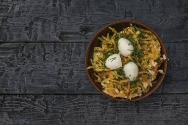 Siyah ahşap bir masada yuva şeklinde bir salatanın üst görüntüsü. Lezzetli besleyici yiyecekler..