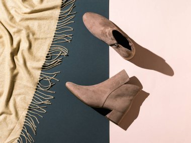 Kumaş ve arka planda iki renkli kadın bej botları. Yarı sezonluk şık kadın ayakkabıları..