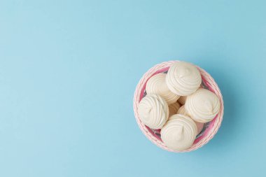 Mavi arka planda bir sepet taze kremanın üst görüntüsü. Yumurta ve şekerin lezzeti.