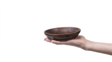 Beyaz arka planda izole edilmiş kilden bir kaseyle bir kızın eli. İçkiler için eski usul tabaklar.