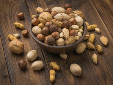 Ahşap bir masanın üzerinde soyulmamış bir sürü fındık var. Vejetaryen yemeği..