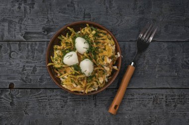 Tahta masadaki bıldırcın yumurtası salatasının yanında bir çatal. Lezzetli besleyici yiyecekler..