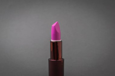 Koyu gri arka planda parlak bir ruj. Kadın yüzüne dikkat et..