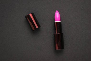 Siyah arka planda parlak, şık bir ruj. Dudak dekorasyonu.