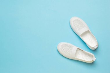 Açık mavi arka planda beyaz yaz kadın ayakkabıları. Hafif kadın ayakkabıları..