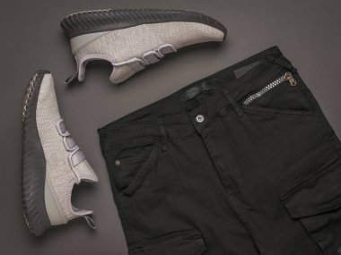 Gri ayakkabılar ve siyah pantolon. Modaya uygun gençlik kıyafetleri..