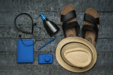 Şapka, kulaklık, kamera ve tahta arka planda not defteri. Seyahat planlama kavramı.