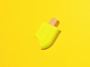 Sarı arka plandaki çubukta sarı dondurma. Popüler bir yaz atıştırması.