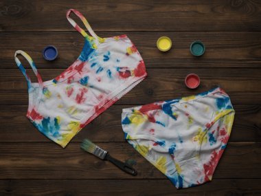 Koyu renkli ahşap bir masaya boya iç çamaşırı bağla. Evde renkli iç çamaşırı var..