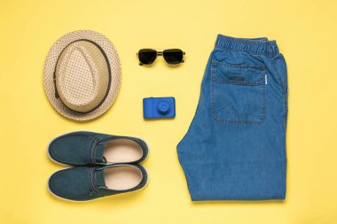 Kamera ve erkek yaz kıyafetleri sarı arka planda. Metin için yer aç. Düz yatıyordu.