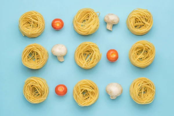 背景是西红柿 蘑菇和扭曲的意大利面蓝色背景 制作意大利面的配料 — 图库照片