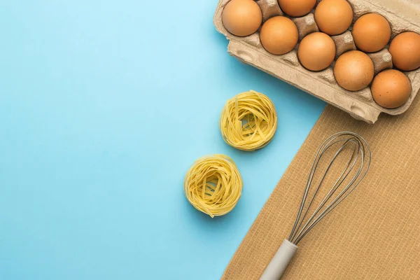 Pasta Una Caja Huevos Batidor Para Batir Sobre Fondo Azul — Foto de Stock