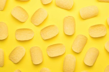 Sarı arka plana saçılmış patates cipsi. Popüler bir patates yemeği. Düz yatıyordu.