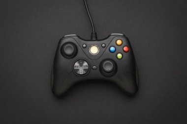 Siyah arka planda siyah oyun konsolu. Bilgisayar oyunları oynamak için bir cihaz. Düz yatıyordu.