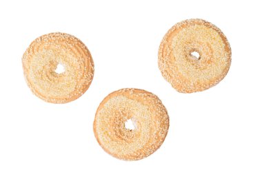 Beyaz arka planda izole edilmiş üç susamlı kurabiyenin üst görüntüsü. Tatlı ev yapımı kekler..