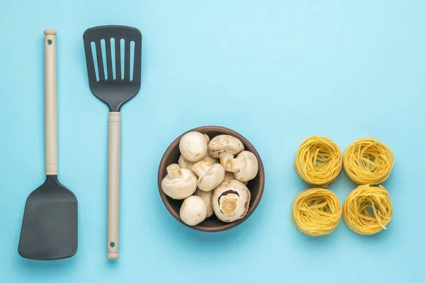 Bowl Mushrooms Kitchen Spatulas Four Skeins Pasta Blue Background Ingredients — Foto de Stock