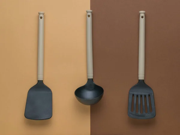 2色の背景に2つのキッチン スパチュラとラドル プラスチックキッチンツール — ストック写真