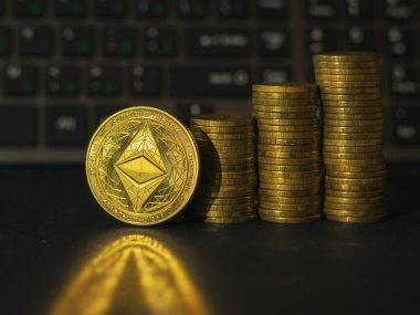 Bir yığın altın para ve siyah arka planda bir metal para. Kripto para biriminin fiyatındaki artış kavramı. Dijital para birimi.