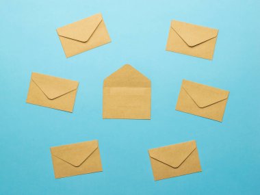 Altı tane kapalı ve mavi arka planda bir tane açık posta zarfı var. Posta yazışmaları kavramı. Düz yatıyordu.