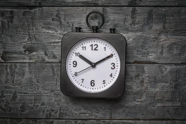 Eine Schwarze Uhr Mit Weißem Zifferblatt Auf Einem Hölzernen Hintergrund — Stockfoto