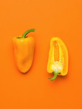 Portakallı dolmalık biberin yarısı turuncu arka planda. Vejetaryen yemeği. Taze sebze mahsulü..