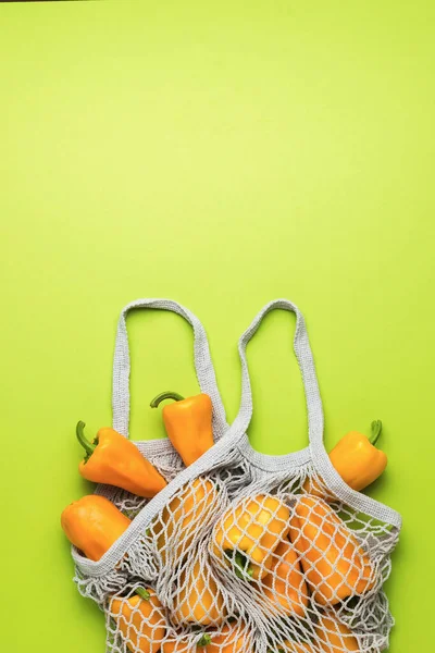 Сетчатый Мешок Оранжевым Перцем Зеленом Фоне Вегетарианская Еда Свежий Урожай — стоковое фото