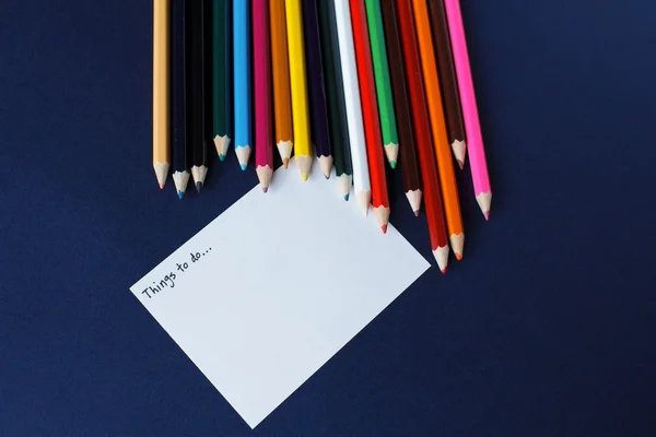 Crayons de couleur et une feuille de papier — Photo