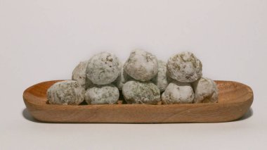 Mochi, a sweet dessert or rice cake filled with chocolate or mung beans, and coated with sesame seeds Mochi cake on a plate with a white background.